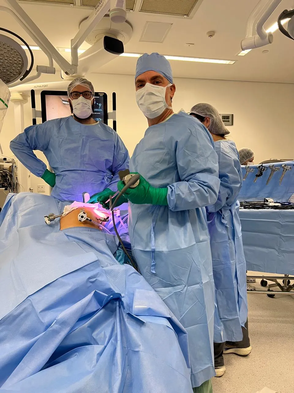 Equipe acompanhando o monitor durante cirurgia laparoscópica